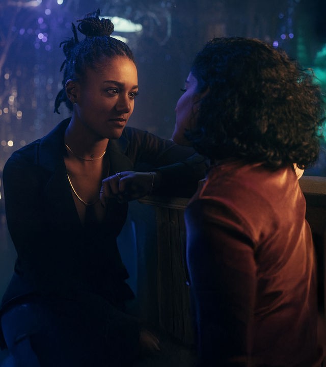 "Loving Her - Loving Anouk": Anouk (Larissa Sirah Herden) und Hanna (Banafshe Hourmadzi) sitzen eng nebeneinander in einem Nachtklub und sehen sich verliebt an.