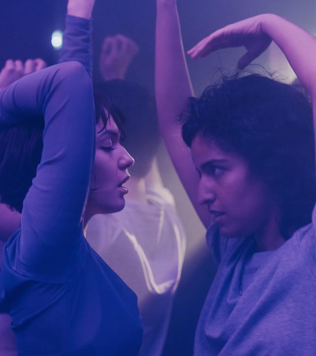 "Loving Her - Loving Lara": Lara (Emma Drogunova) und Hanna (Banafshe Hourmazdi) stehen sich in einem Klub auf der Tanzfläche gegenüber und tanzen miteinander.