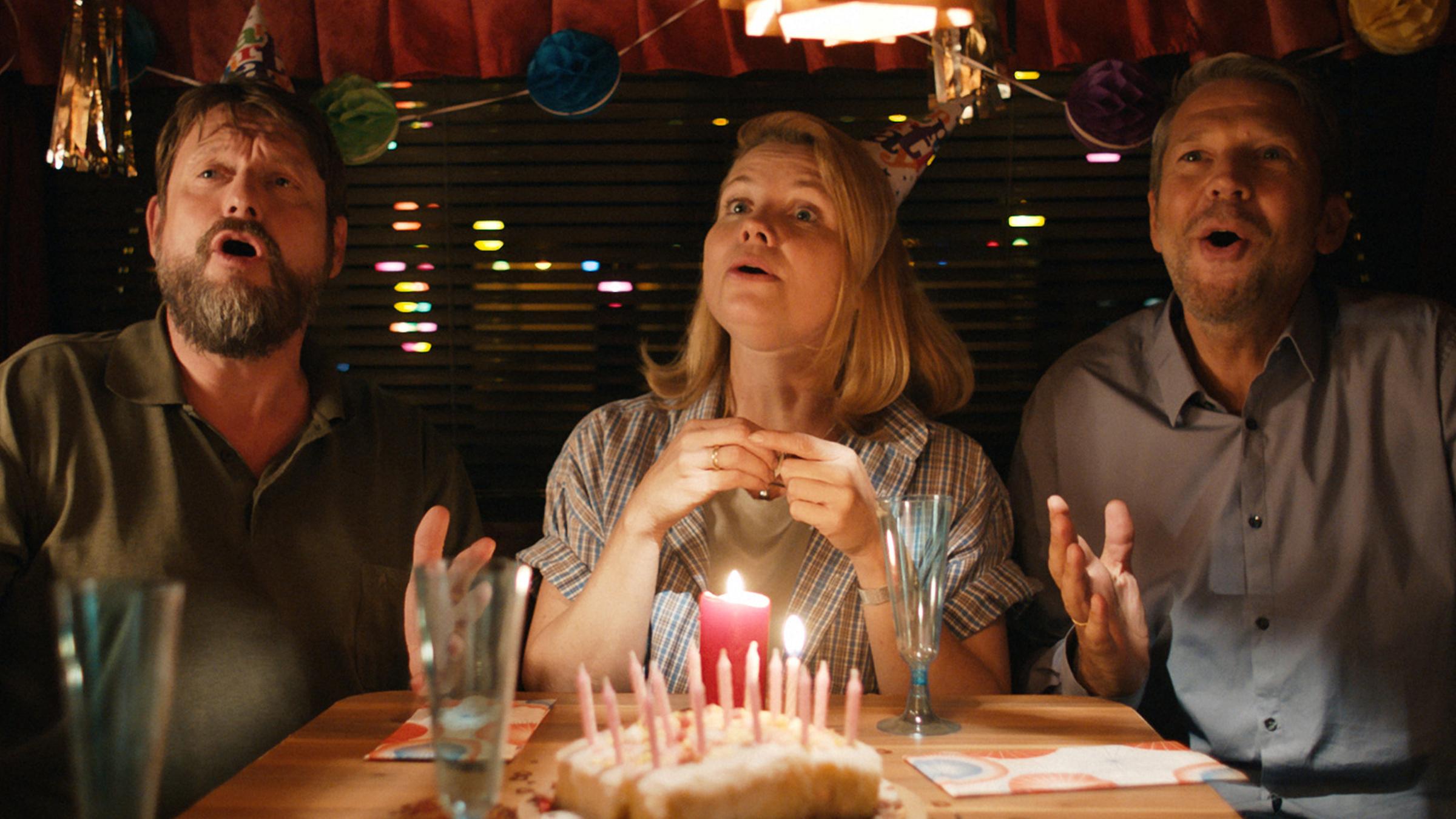 Mike (Peter Trabner) singt mit Claudia (Annette Frier) und Thomas (Kai Wiesinger) im dekorierten Wohnwagen ein Geburtstagsständchen.
