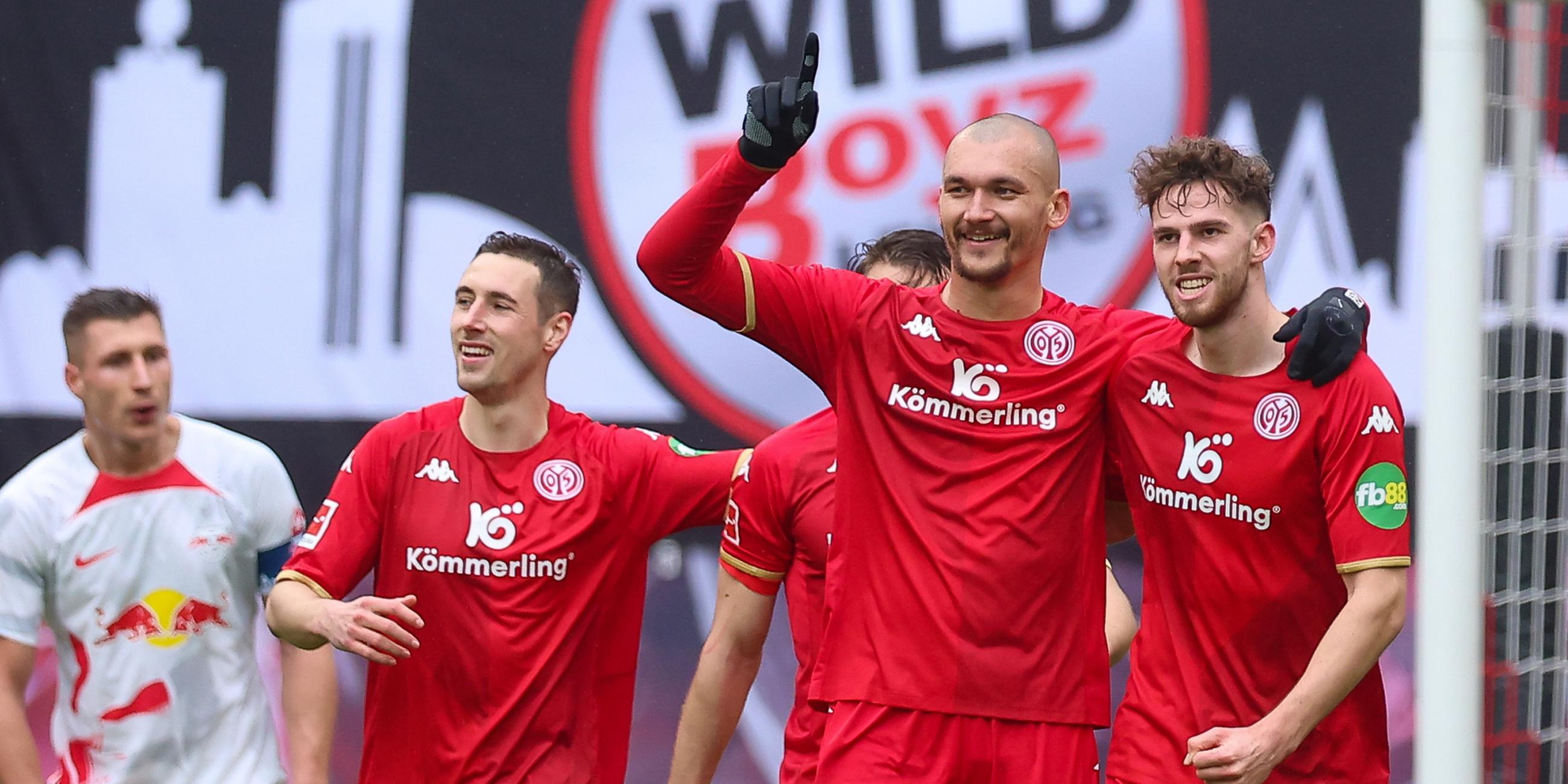 Die Mainzer Spieler Dominik Kohr (2.v.l.-r), Ludovic Ajorque (M) und Anton Stach jubeln über das 0:2 durch Ajorque.