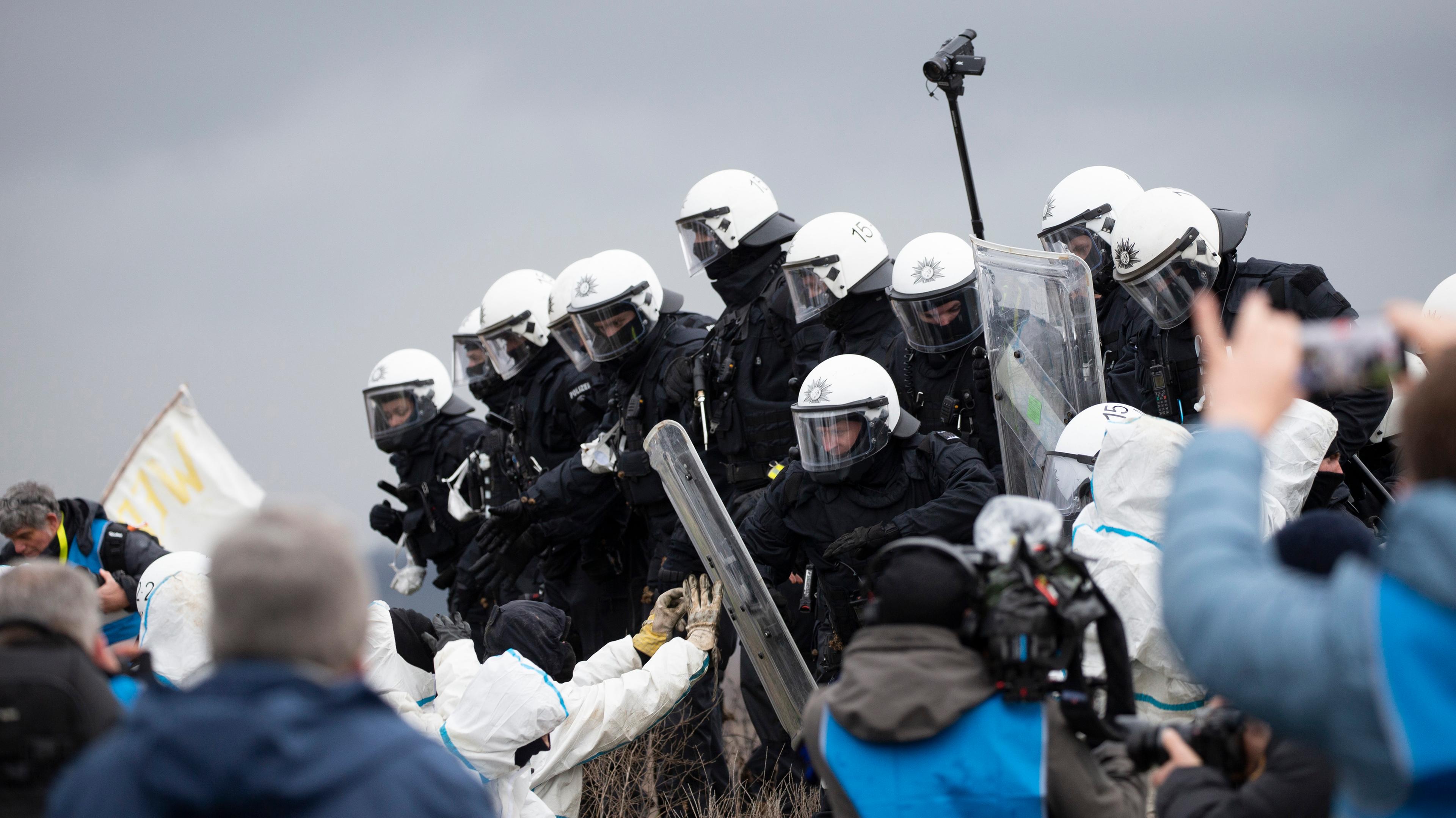 Bei den Vorbereitungen zur geplanten Räumung des Dorfes Lützerath drängen Polizeibeamte Aktivisten von einem Erdwall zurück am 02.01.2023.