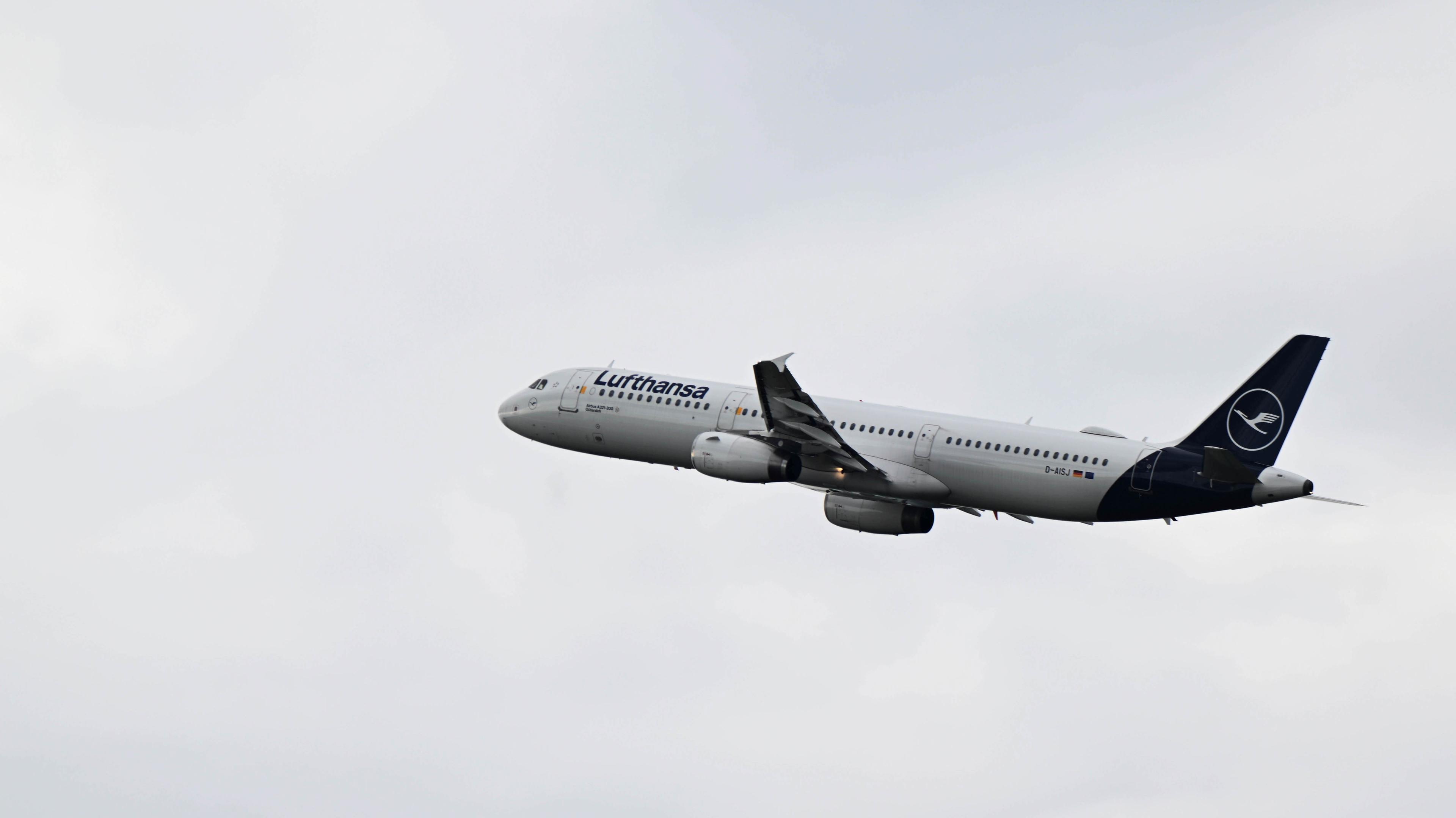 Bayern, München: Ein Airbus A321-200 der Lufthansa steigt in den Himmel hinter dem Flughafen München. 