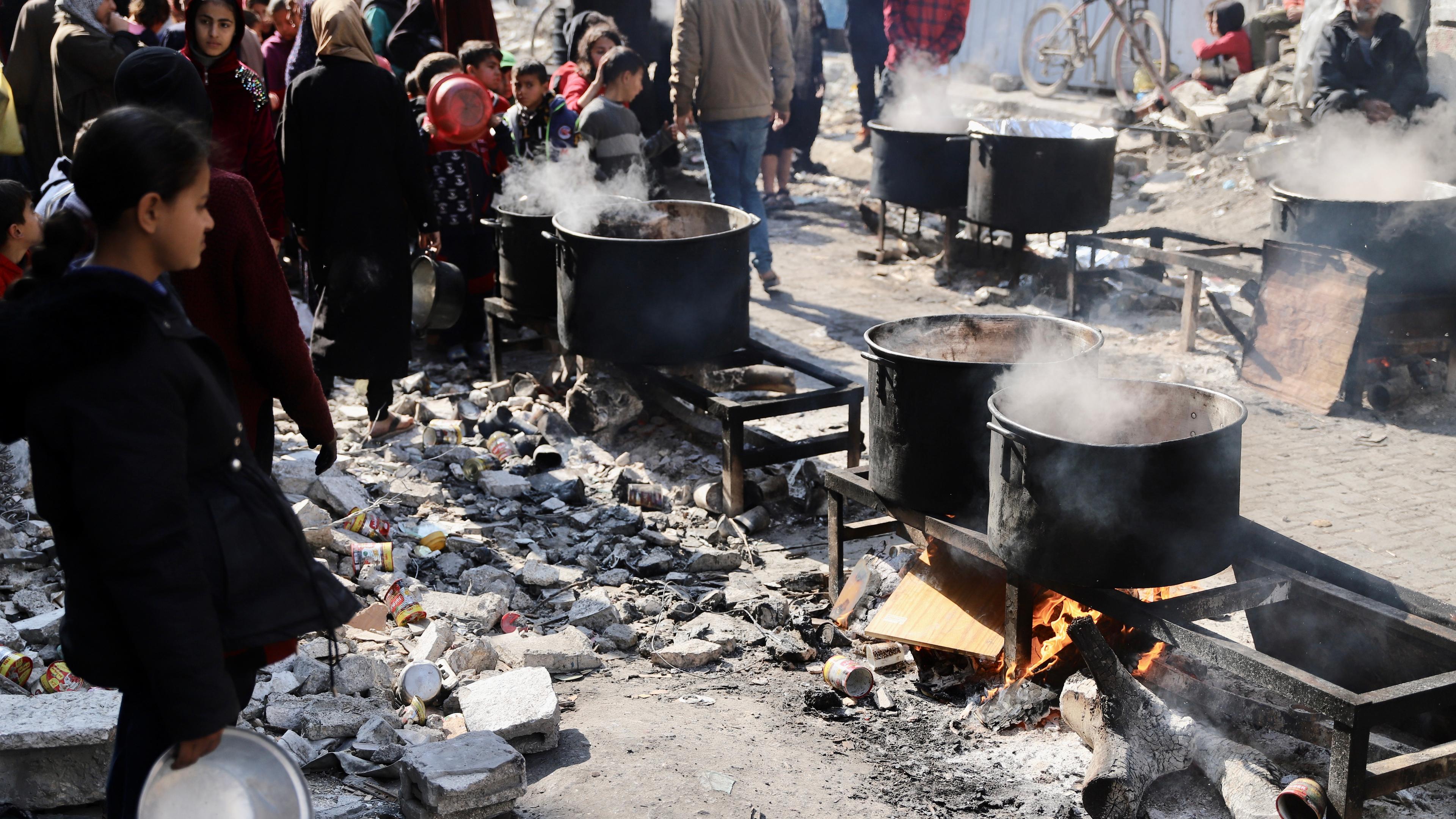 Archiv, 27.02.2024, Palästinensische Gebiete: Menschen warten in einem Flüchtlingslager im nördlichen Gazastreifen auf gekochtes Essen.