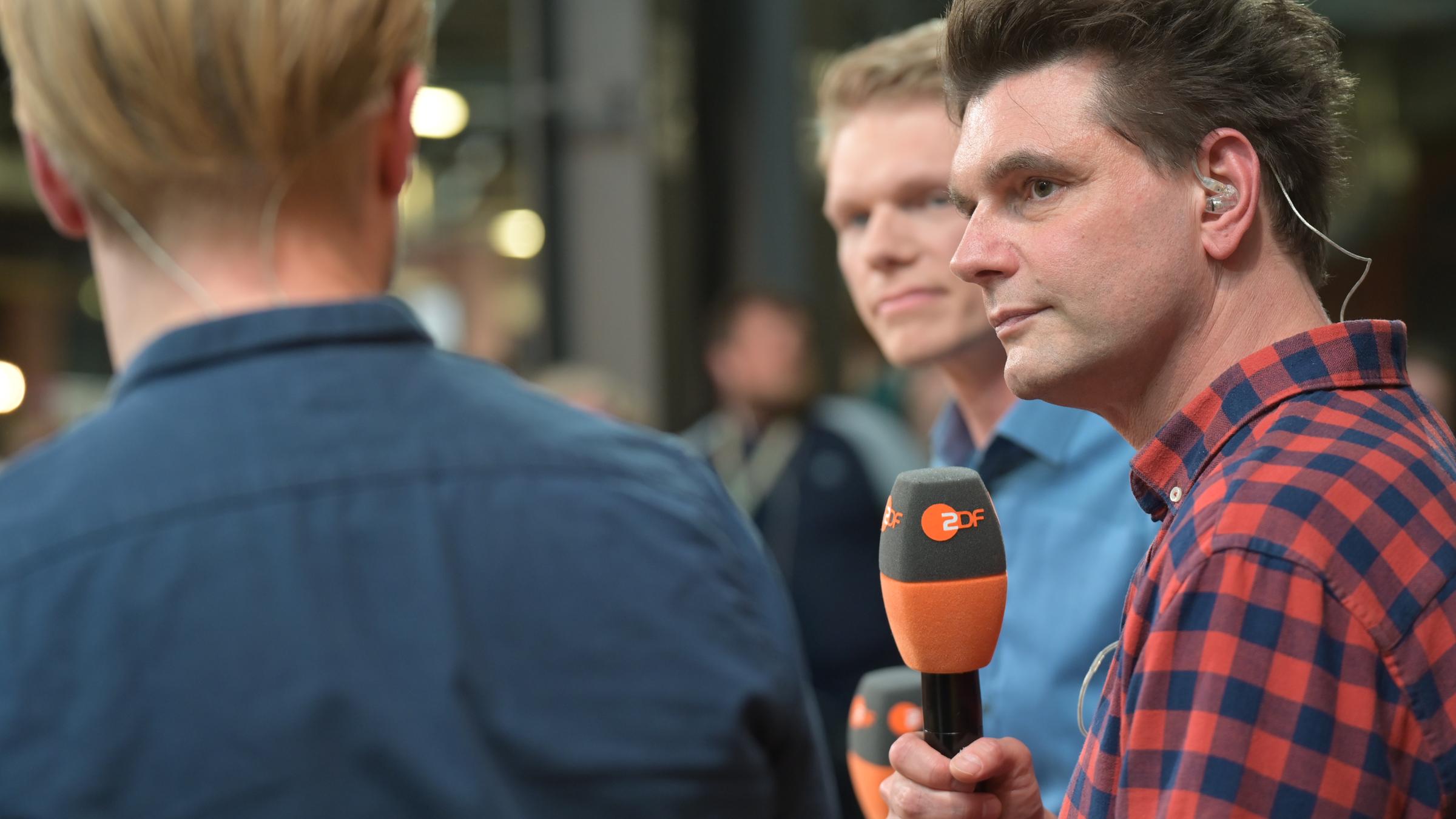 Während der re:publica 2025-Session zur heute-show online: Lutz van der Horst mit ZDF-Mikrofon in der Hand, seitlich aufgenommen.