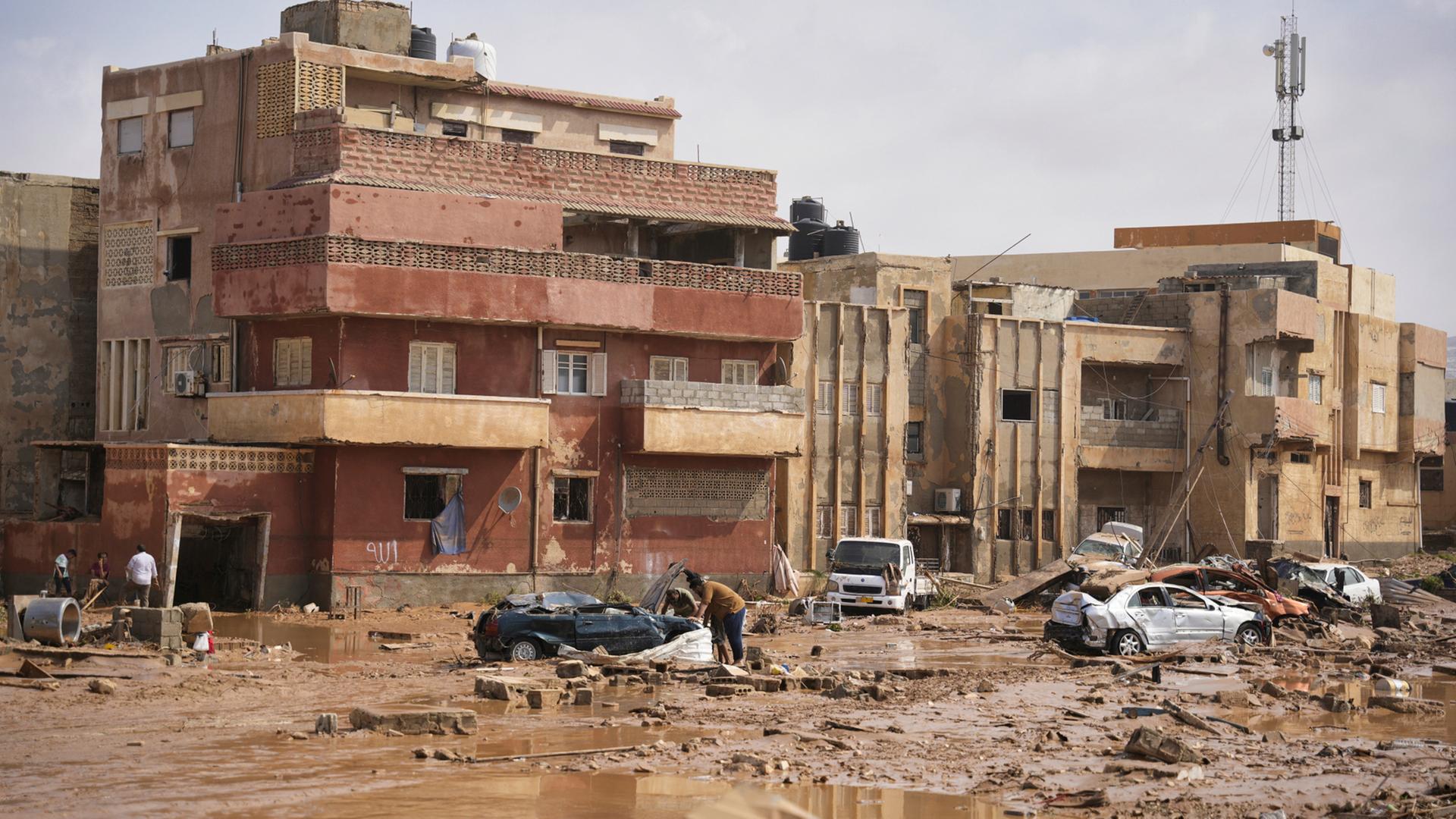 Libyen, Darna: Auf diesem von der libyschen Regierung zur Verfügung gestellten Bild liegen Autos und Trümmer in einer Straße in Darna, Libyen, nachdem sie durch starke Regenfälle überflutet wurde