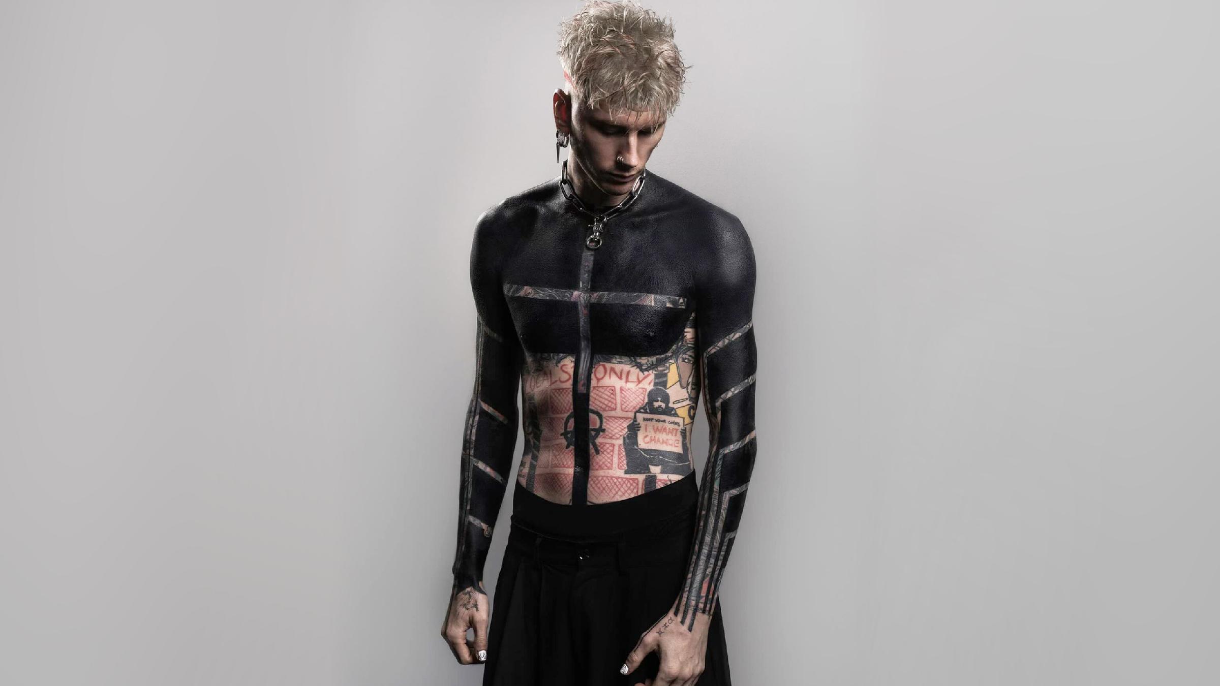 Machine Gun Kelly mit einem Blackout-Tattoo auf dem Oberkörper