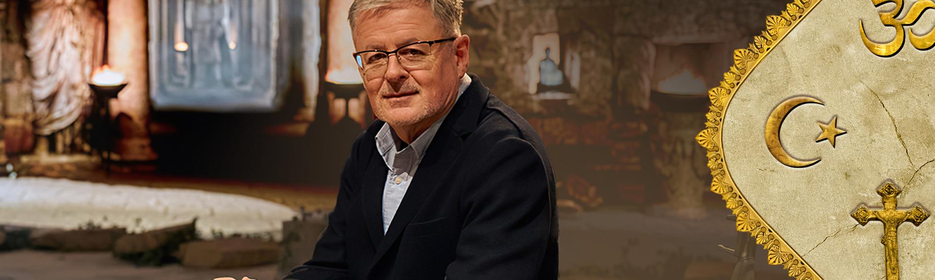 Christopher Clark sitzt an einem Tisch, neben ihm ein Schale und eine Bibel