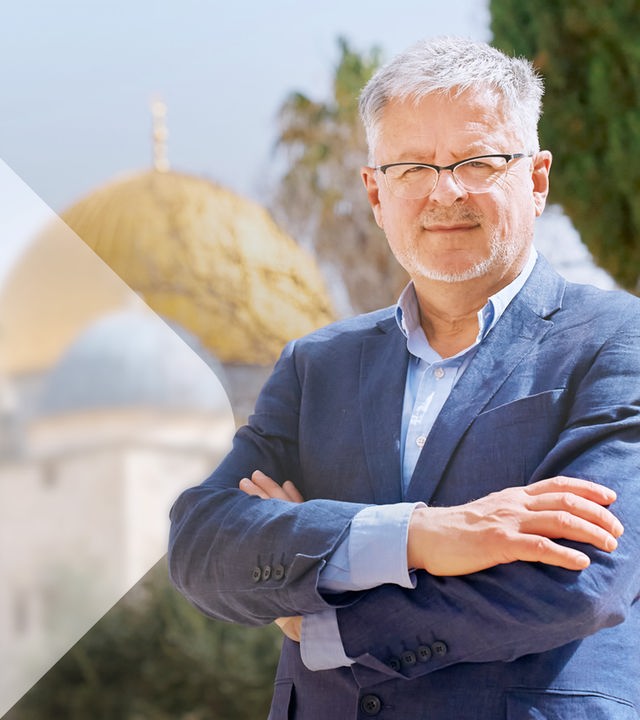Christopher Clark sitzt an einem Tisch, neben ihm ein Schale und eine Bibel