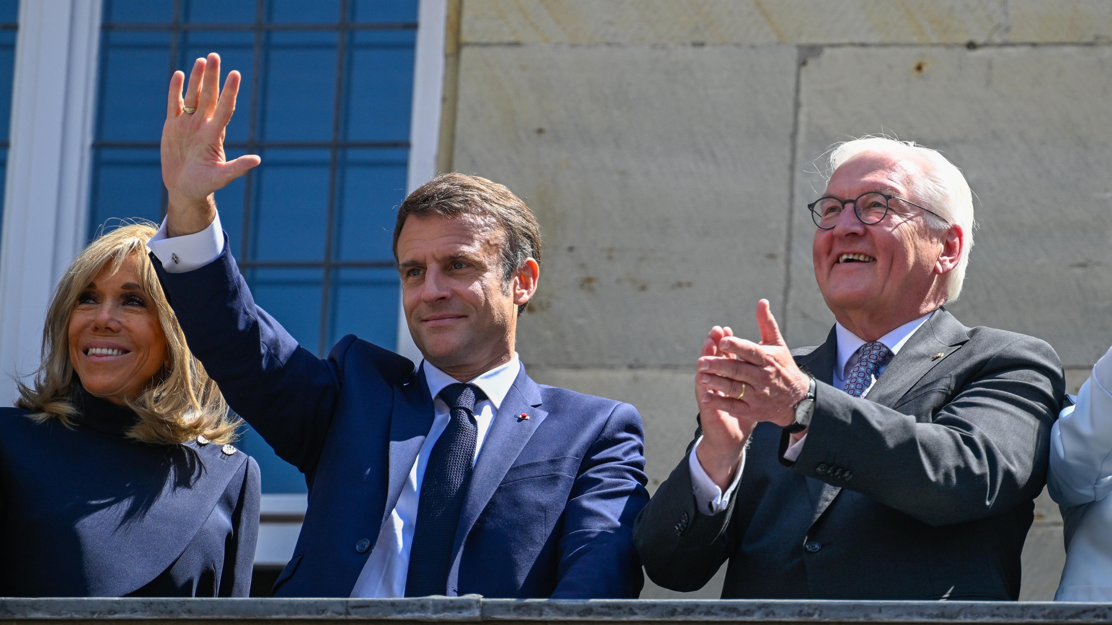 French President Emmanuel Macron (C) flanked by his wife Brigitte Macron (L) and German President Frank-Walter Steinmeier (R) wave from the balcony of the historical city hall on the third day of his state visit to Germany, in Muenster, Germany, 28 May 2024