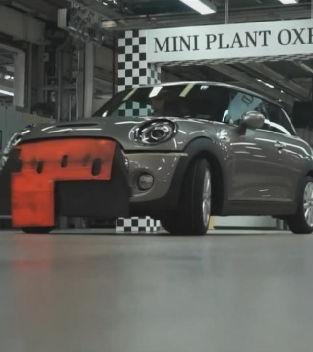 Mini Cooper-Auto in Montagehalle, darüber Schild mit der Aufschrift "Mini Plant Oxford"