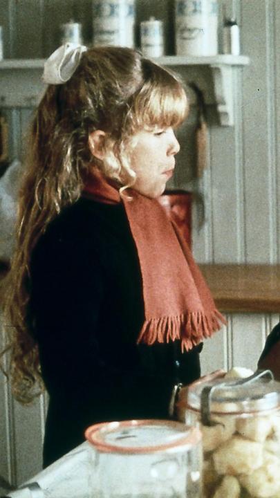 Madita steht in der Küche und beobachtet, wie Äpfel geschält werden.