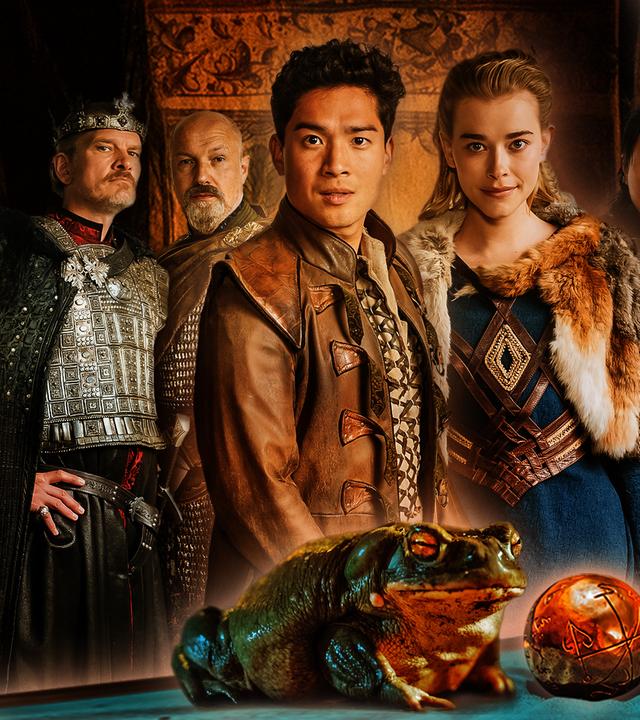 Sechs Personen in mittelalterlichen Gewändern schauen den Betrachter an. Von links: Neben einem groß gewachsenen älteren König, gespielt von Götz Otto, steht ein kräftiger Waffenmeister, gepielt von Simon Werner. Im Vordergrund in der Mitte präsentieren sich ein junger Prinz asiatischer Abstammung, verkörpert von Jan Liem, und eine blonde Prinzessin in einem blauen Kleid, dargestellt von Milena Tscharntke. Wieder etwas im Hintergrund sieht man einen jüngeren Mann mit schwarzen Haaren, gespielt von Anh Alexander Tran, und eine junge Frau mit kurzen blonden Haaren, verkörpert von Lea Drinda. Hinter ihnen sind braune bemalte Tücher gespannt. Ganz im Vordergrund sitzt ein Frosch neben einer goldenen Kugel.