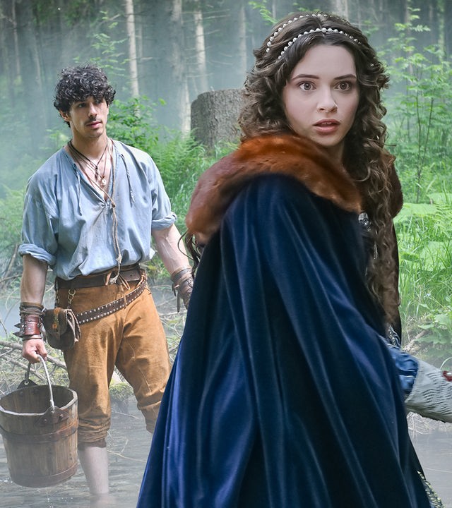 Tagsüber im Wald: Verängstigt dreht sich Julia (Katarína Krajčovičová) um. Sie trägt einen dunkelblauen Umhang mit braunem Pelzkragen. In ihren dunklen, langen Haaren sind Perlen eingearbeitet. Im Hintergrund steht Juraj (Ladislav Bédi) barfuß mit einem Holzeimer in einem Bach. Im Hintergrund steigen Nebelschwaden im Wald auf.