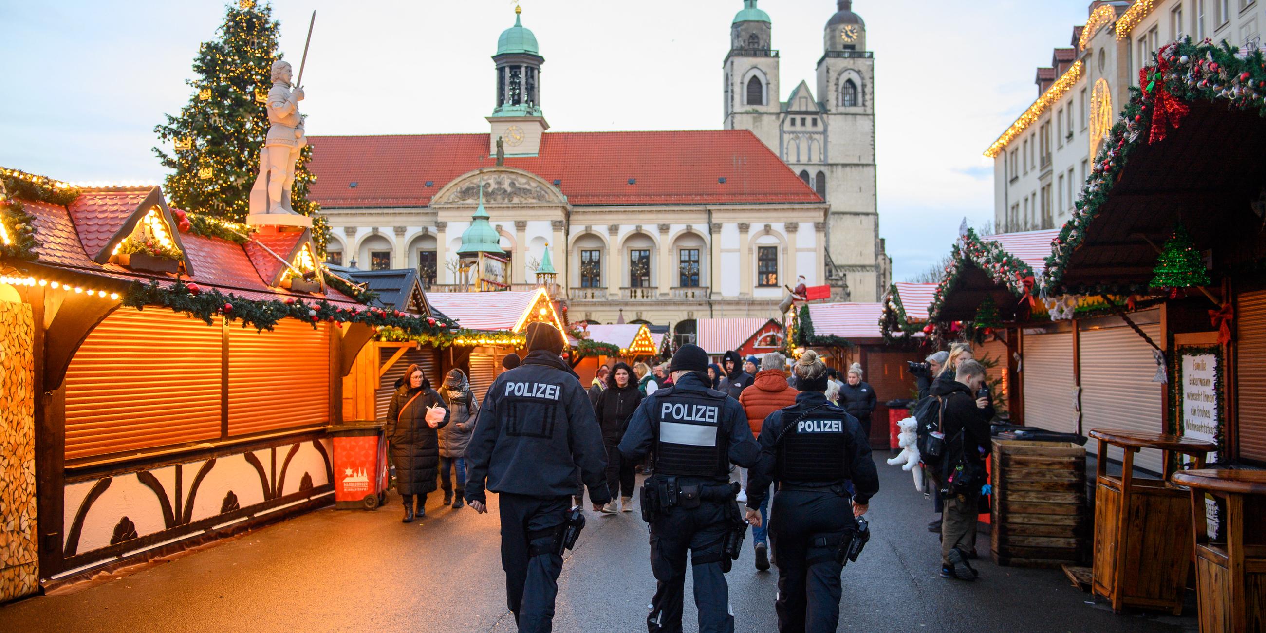 Drei Polizisten gehen über den Magdeburger Weihnachtsmarkt