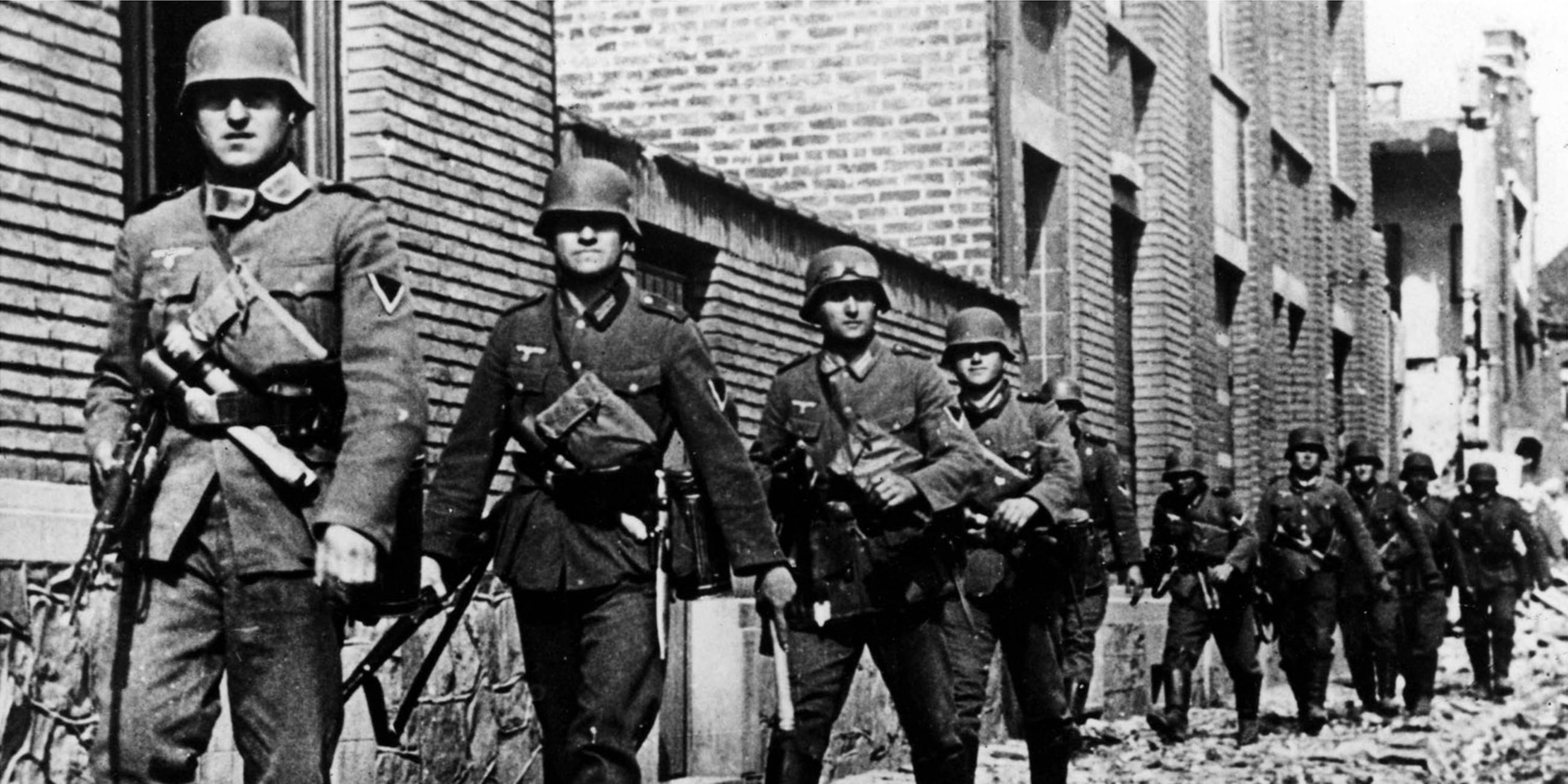 Mai 1940: Deutsche Truppen marschieren durch eine Straße in einer belgischen Stadt