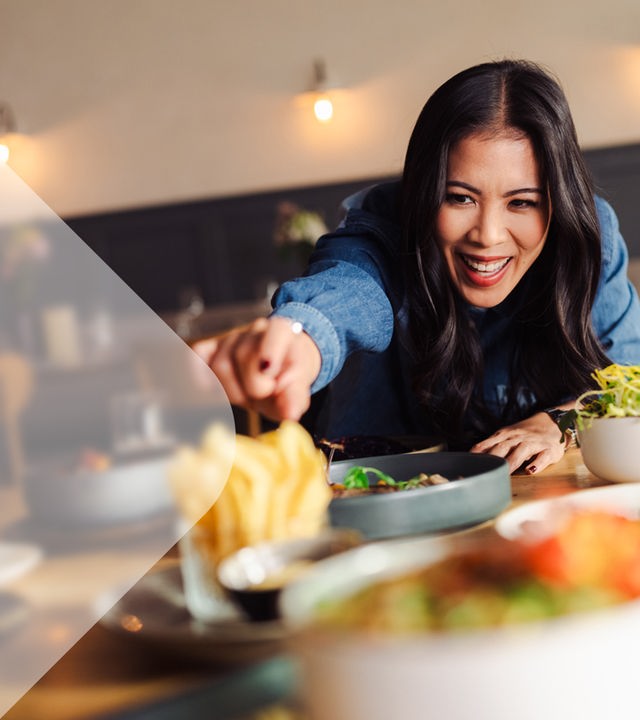 Moderatorin Mai Thi Nguyen-Kim in einem Restaurant vor gedecktem Tisch