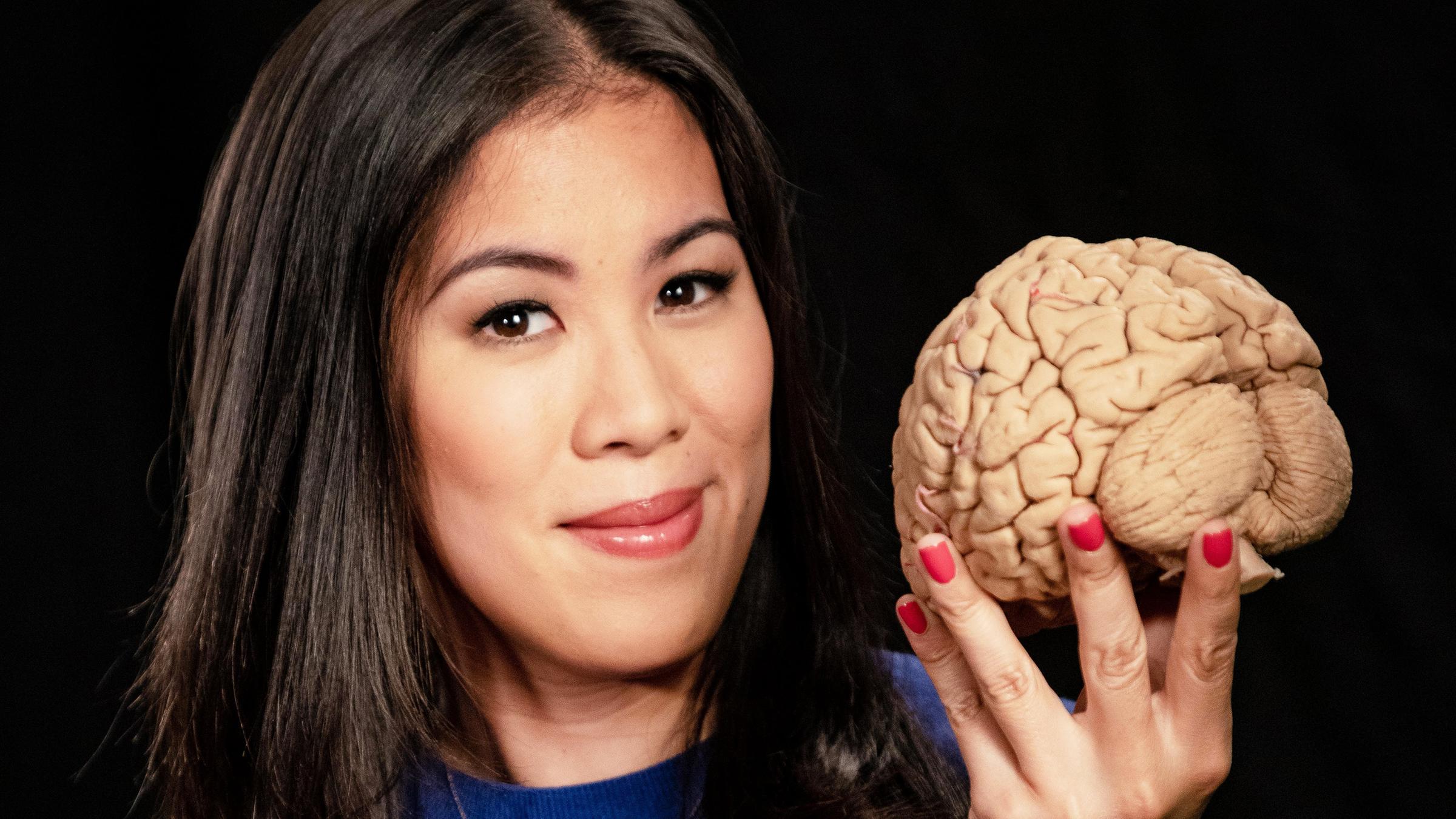 Moderatorin Mai Thi Nguyen-Kim hält in der rechten Hand das Modell eines menschlichen Gehirns.