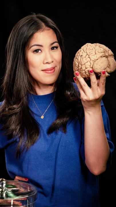 Moderatorin Mai Thi Nguyen-Kim hält in der rechten Hand das Modell eines menschlichen Gehirns.