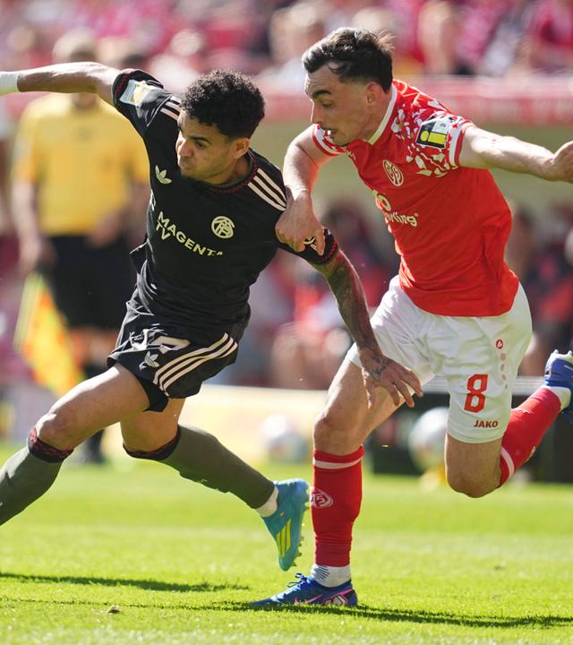 Bayerns Flügelspieler Luis Diaz kann sich im Zweikampf mit dem Mainzer Mittelfeldspieler Paul Nebel durchsetzen