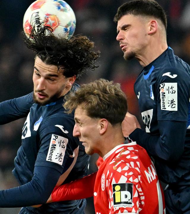 Leon Avdullahu, Albian Hajdari und Nelson Weiper steigen im Bundesligaspiel zwischen dem FSV Mainz 05 und der TSG 1899 Hoffenheim zum Kopfball hoch.