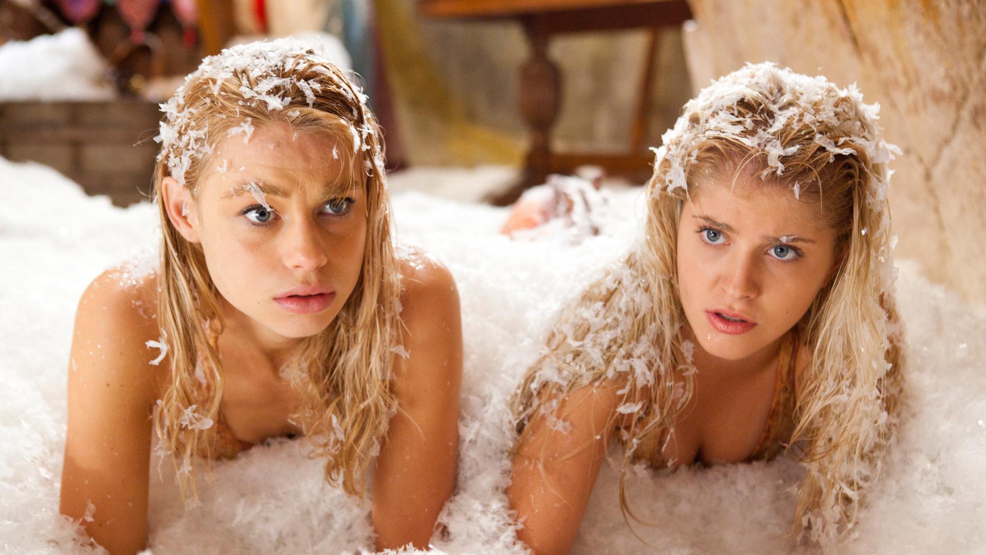 Die Meerjungfrauen Lyla und Sirena liegen in der Grotte in einem Schneehaufen und schauen überrascht.
