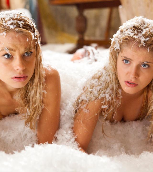 Die Meerjungfrauen Lyla und Sirena liegen in der Grotte in einem Schneehaufen und schauen überrascht.