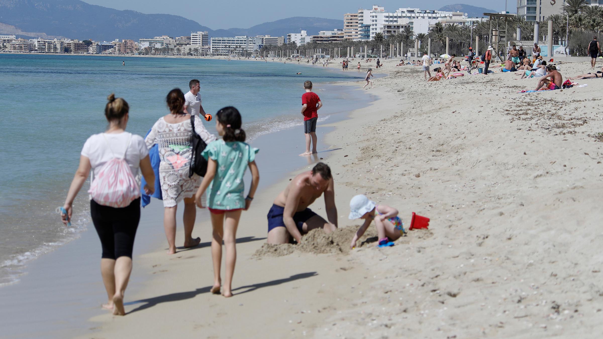 Ende März 2020: Menschen gehen am Strand von El Arenal spazieren.