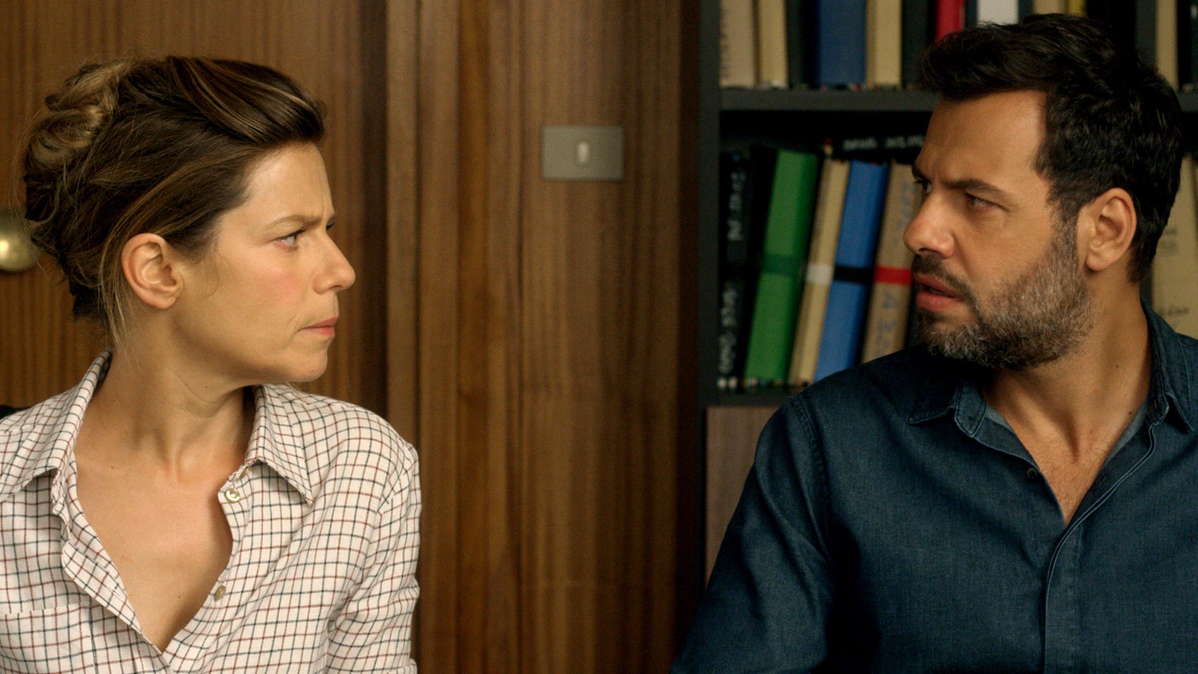 Florence (Marina Foïs) und Vincent (Laurent Lafitte) sitzen nebeneinander am Schreibtisch und schauen sich böse an.