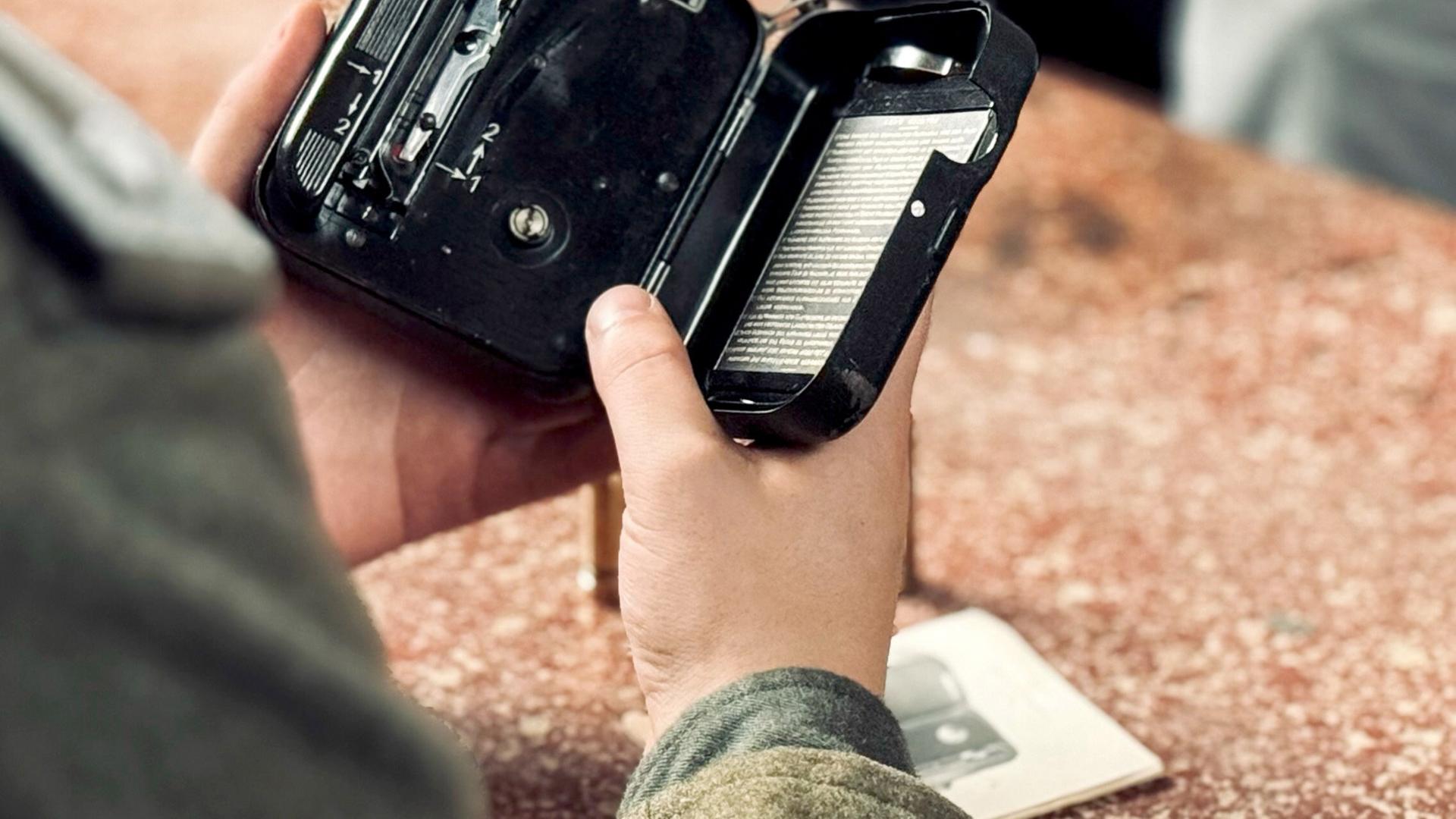 In eine kleine handliche alte Filmkamera wird ein Film eingelegt