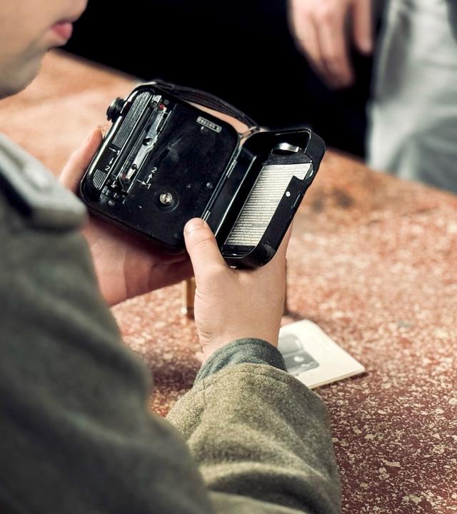 In eine kleine handliche alte Filmkamera wird ein Film eingelegt