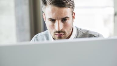 Mann schaut konzentriert Computer