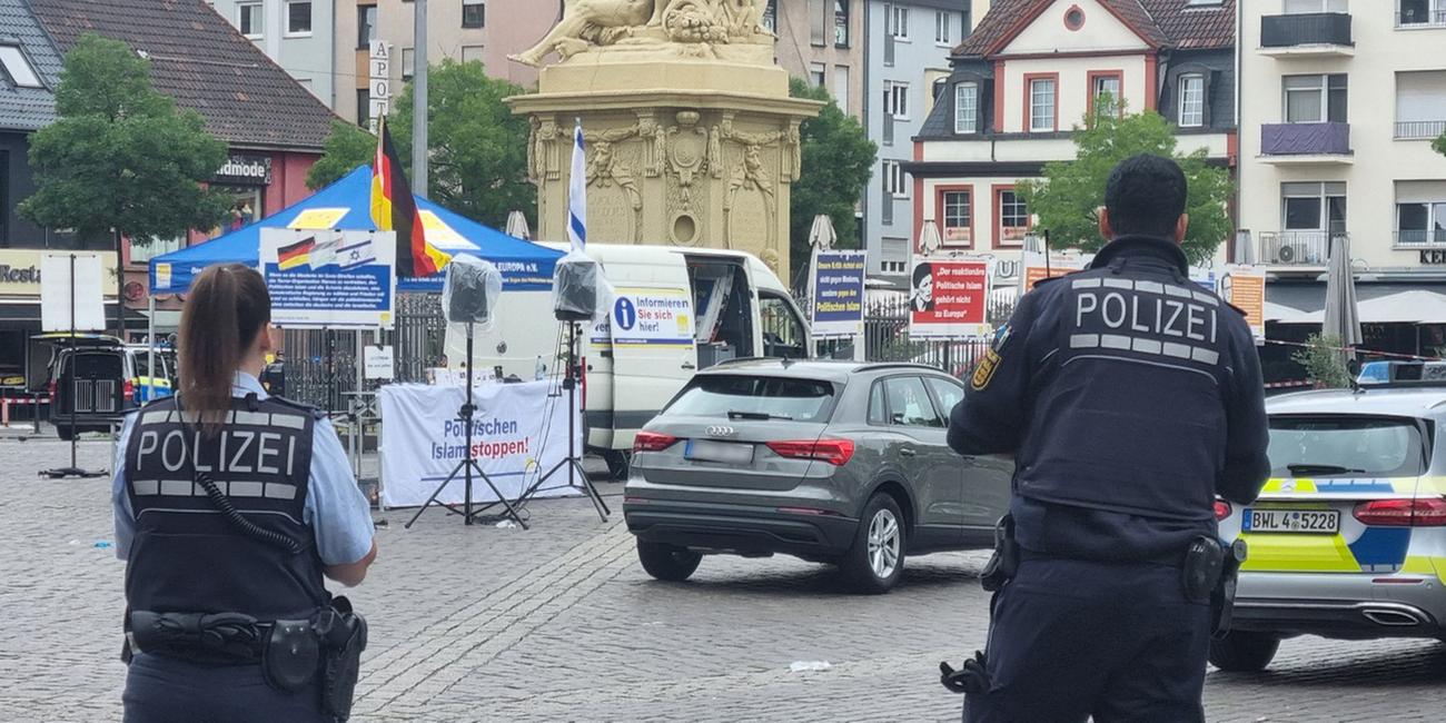 Zwei Polizisten stehen vor dem Mannheimer Markplatz nach einem Messerangriff
