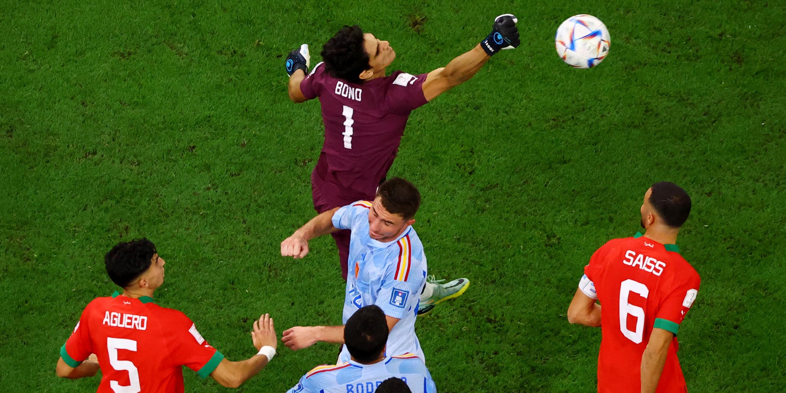 WM 2022: Marokkos Torwart Yassine Bounou faustet den Ball. Romain Saiss und Nayef Aguerd versuchen, die Spanier Aymeric Laporte und Rodri zu blocken.