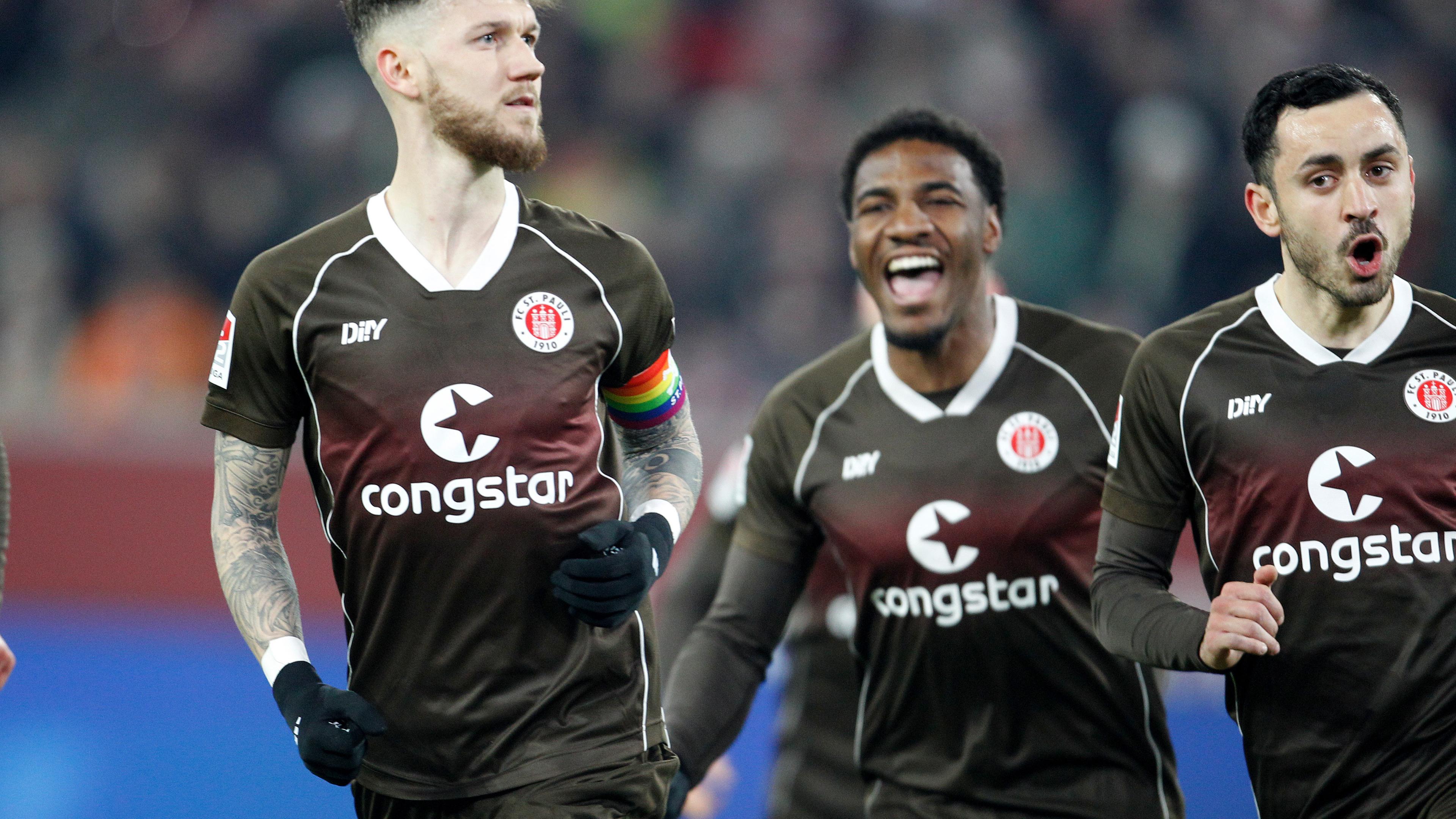 Marcel Hartel jubelt mit Oladapo Afolayan und Manolis Saliakas über das 1:0 für St. Pauli am 27.01.2024.
