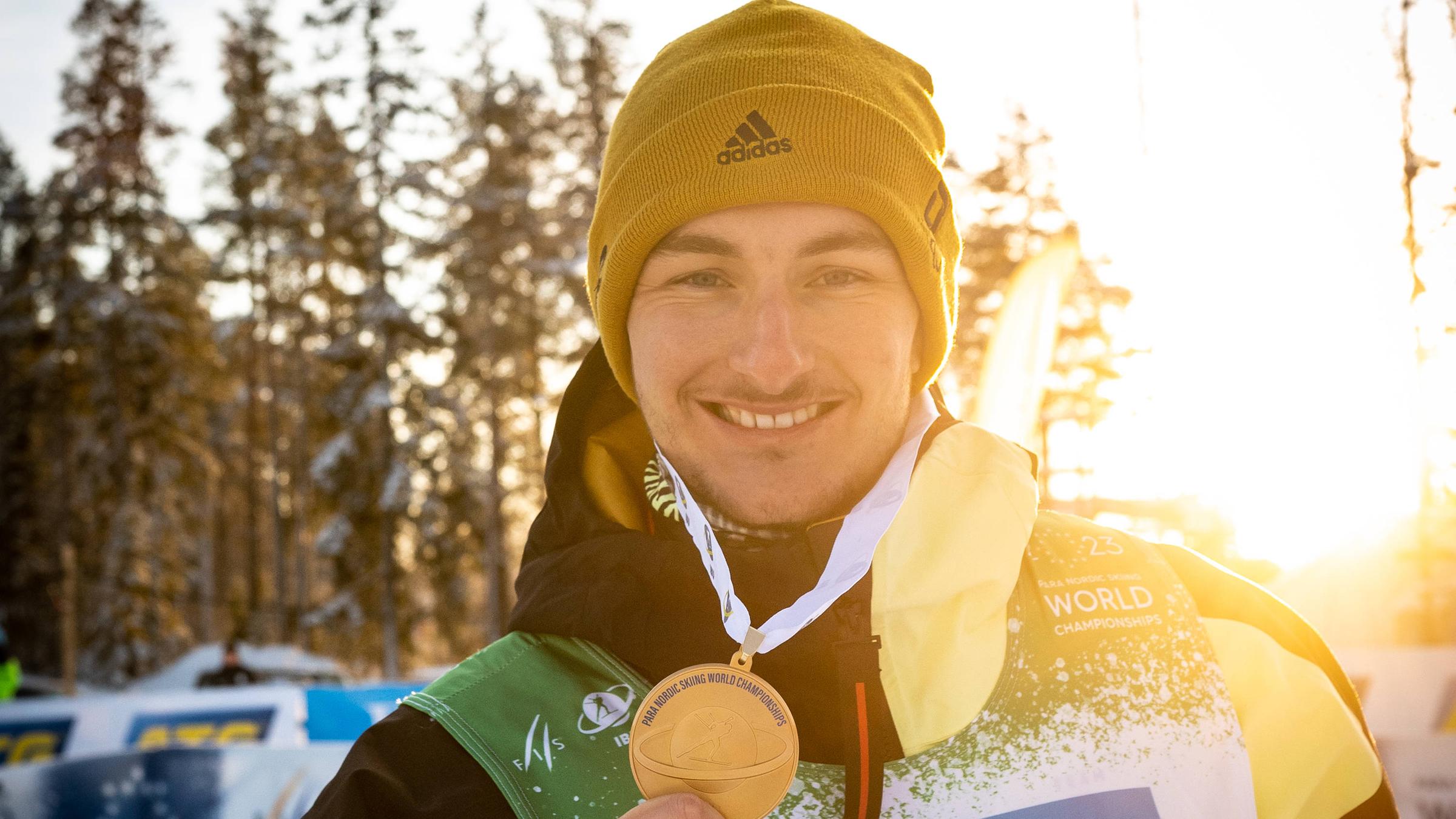 Para-Skiläufer der eine Goldmedaille in der Hand hält 