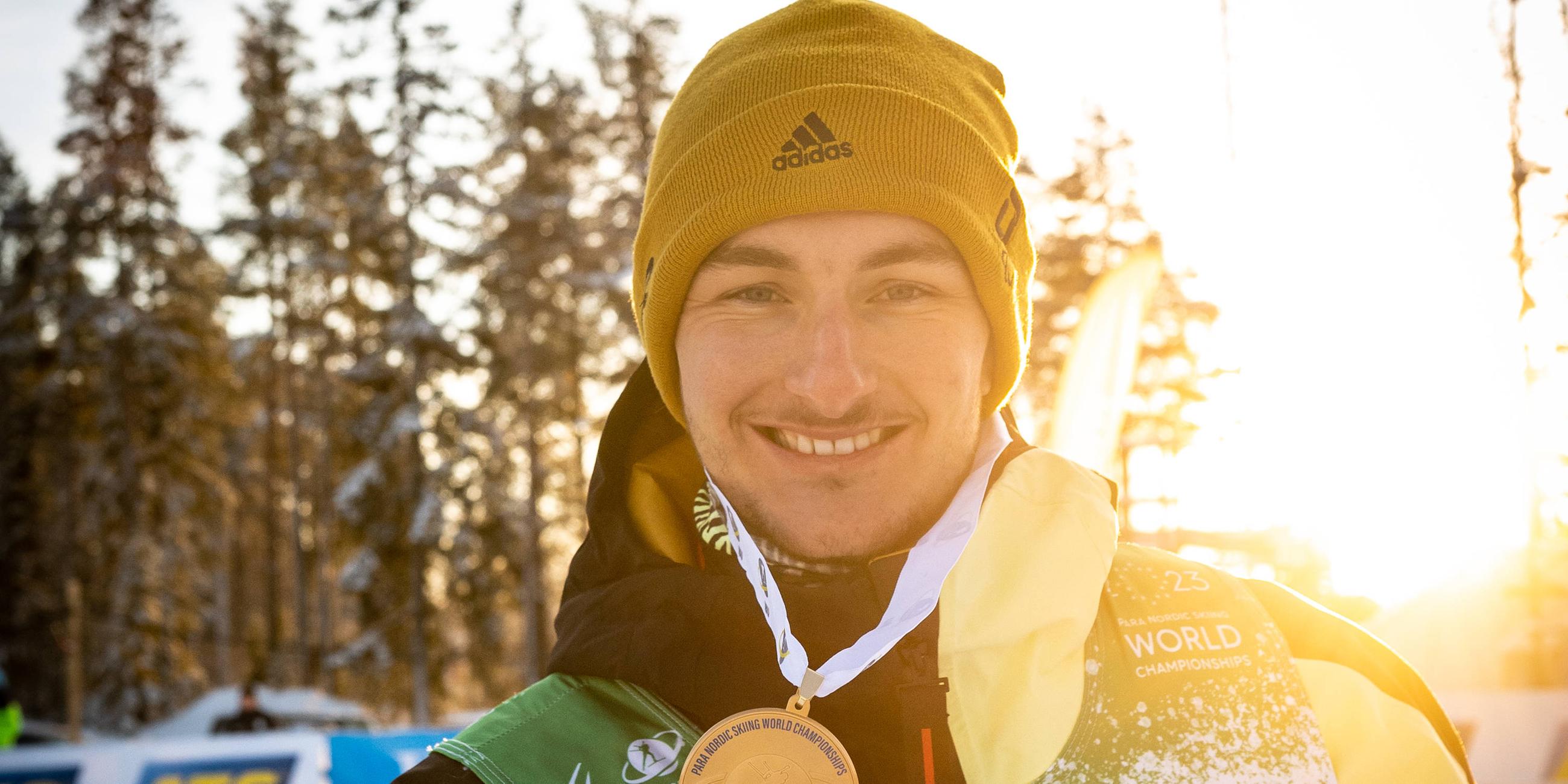 Para-Skiläufer der eine Goldmedaille in der Hand hält 