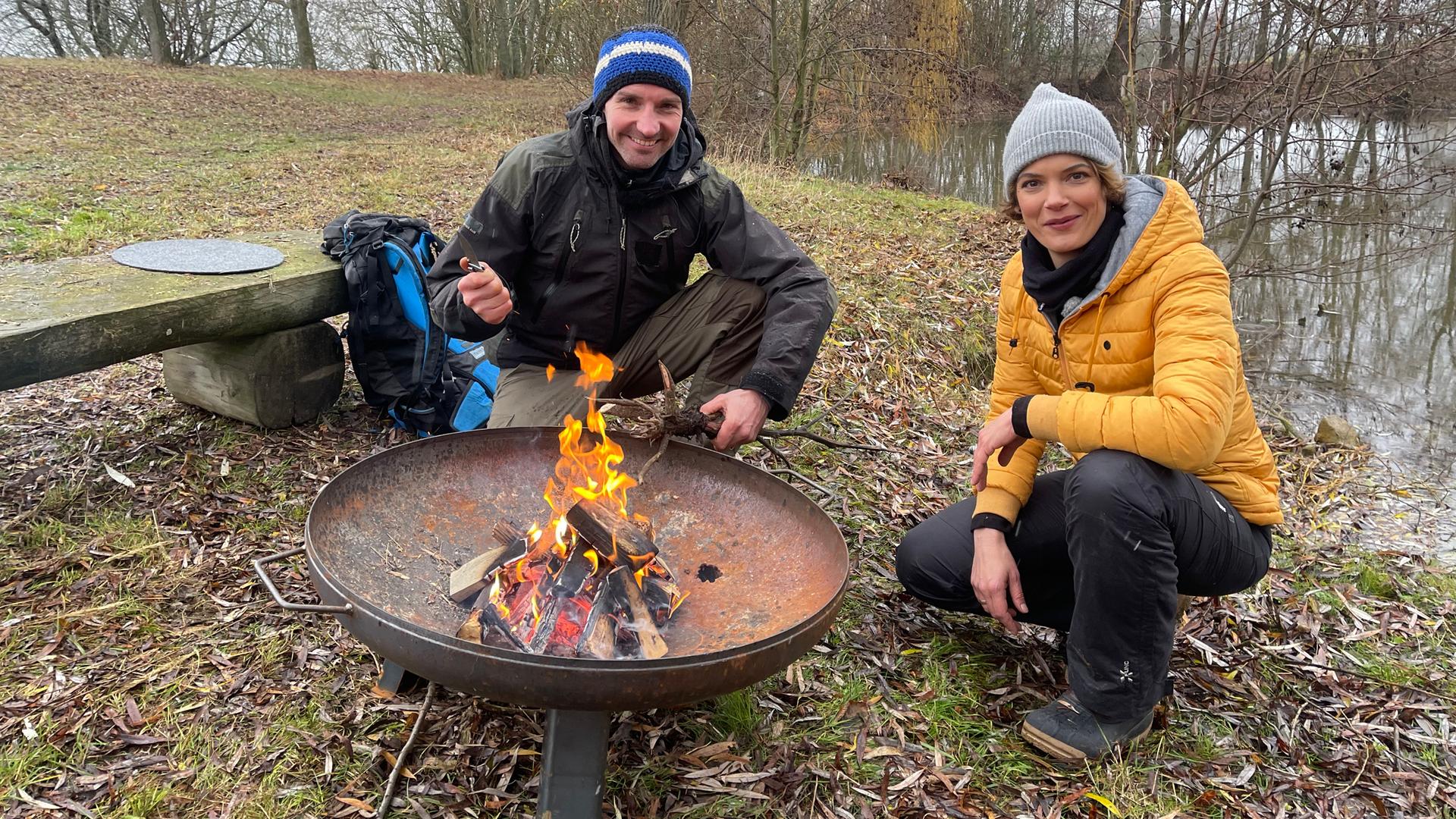 Moderatorin Lena Ganschow mit dem Survival-Experten Marco Plaß am Feuer.