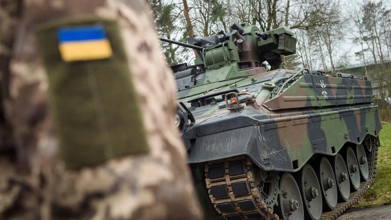 Archives : Un soldat ukrainien se tient devant un véhicule blindé de transport de troupes Marder, le lundi 20 février 2023.
