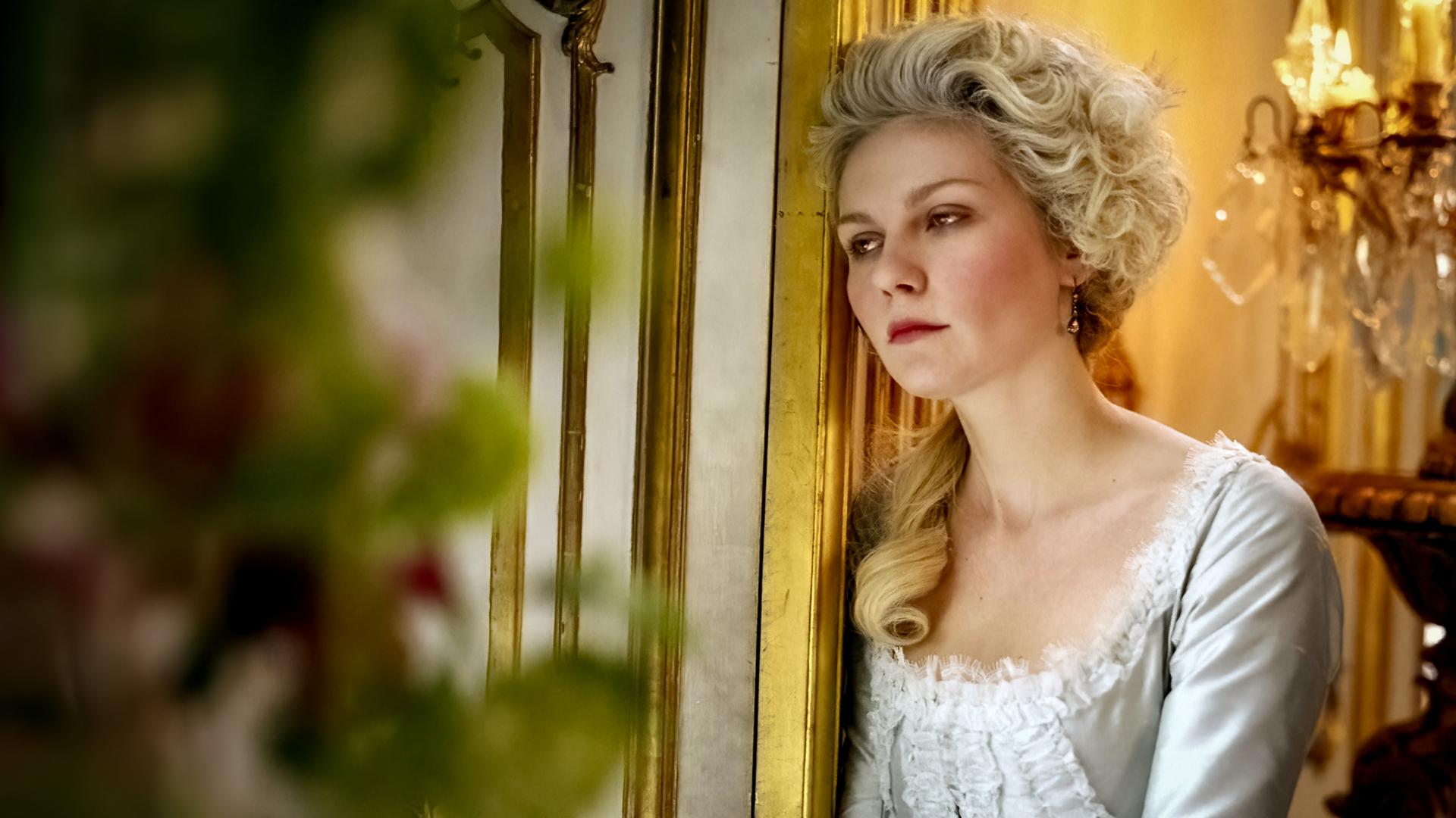 Großaufnahme von Marie Antoinette (Kirsten Dunst), die sich mit nachdenklichem Gesichtsausdruck an einen Türrahmen lehnt.