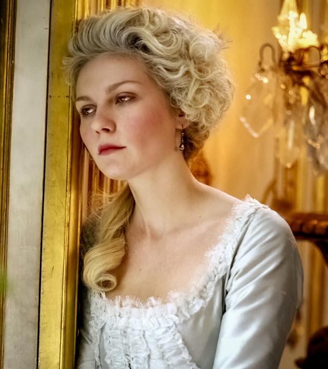 Großaufnahme von Marie Antoinette (Kirsten Dunst), die sich mit nachdenklichem Gesichtsausdruck an einen Türrahmen lehnt.