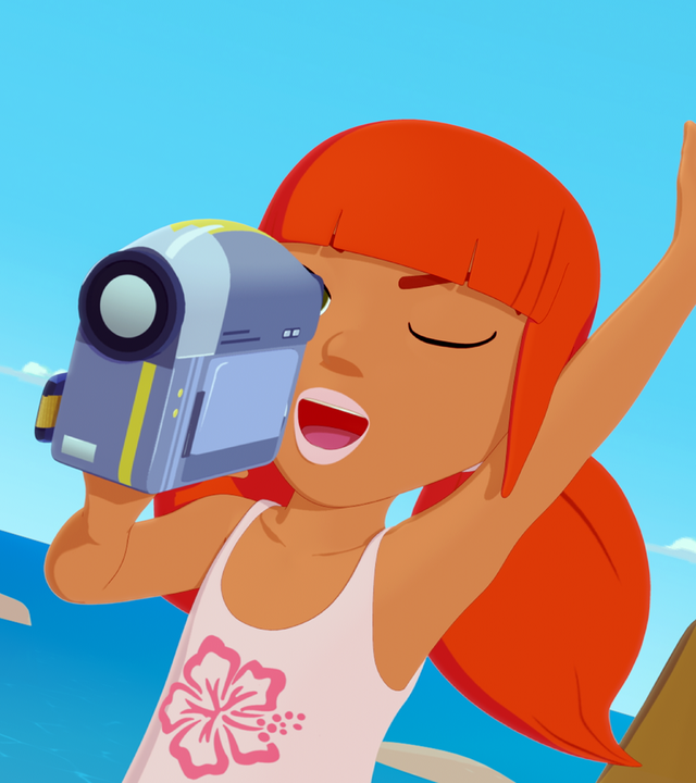 Marina hält in ihrer rechten Hand eine Kamera und schaut mit ihrem rechten Auge durch den Sucher. Ihr linkes Auge ist geschlossen und ihre linke Hand in die Luft gestreckt. Hinter ihr ist das Meer.