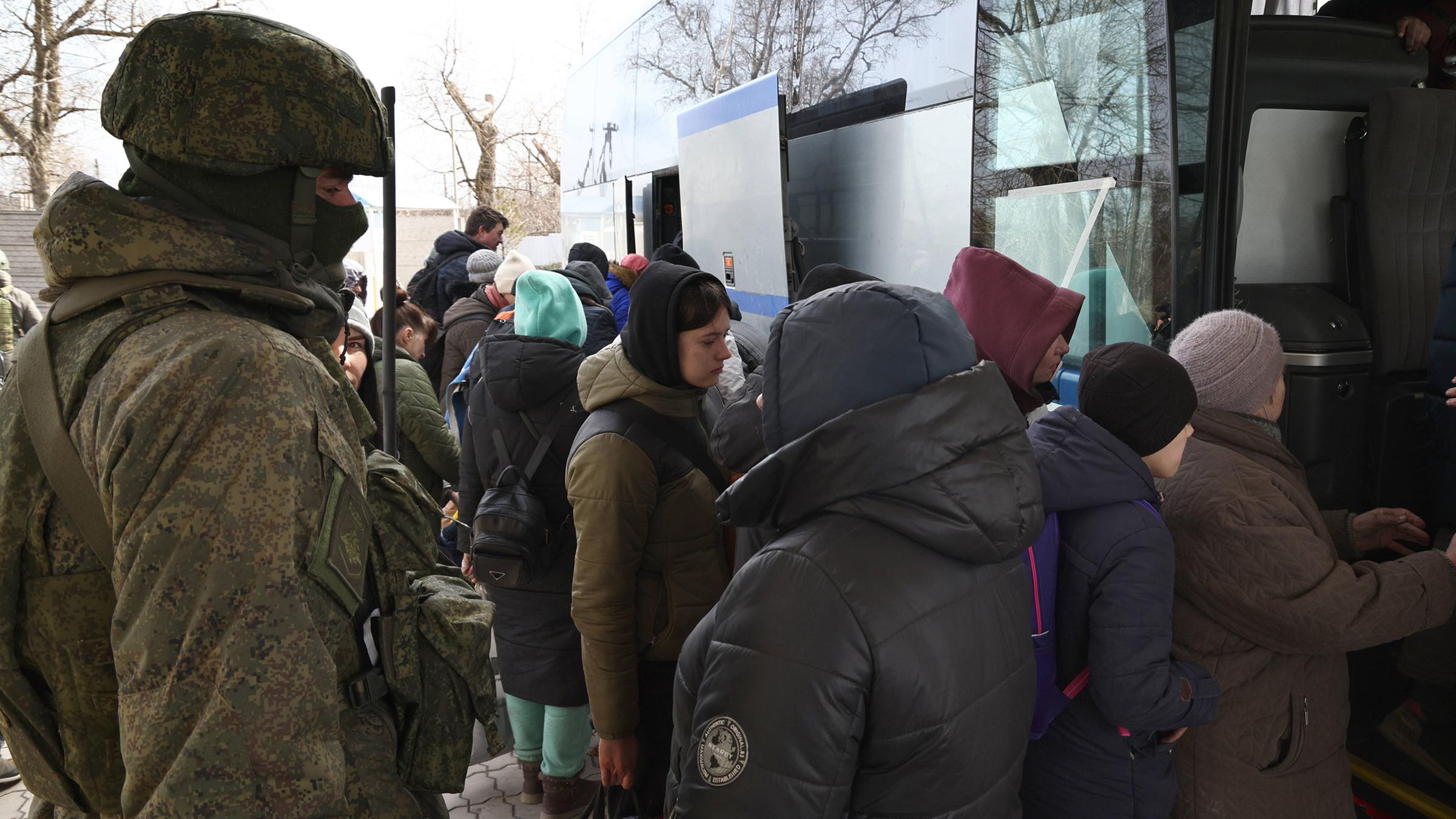Ein russischer Soldat beaufsichtigt die Evakuierung von Ukrainern in Mariupol