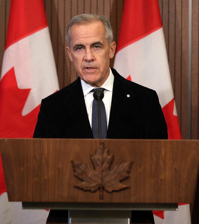 Der kanadische Premierminister, Mark Carney, steht vor einem Rednerpult; im Hintergrund kanadische Flaggen.