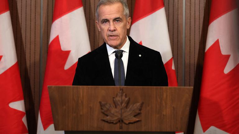Der kanadische Premierminister, Mark Carney, steht vor einem Rednerpult; im Hintergrund kanadische Flaggen.