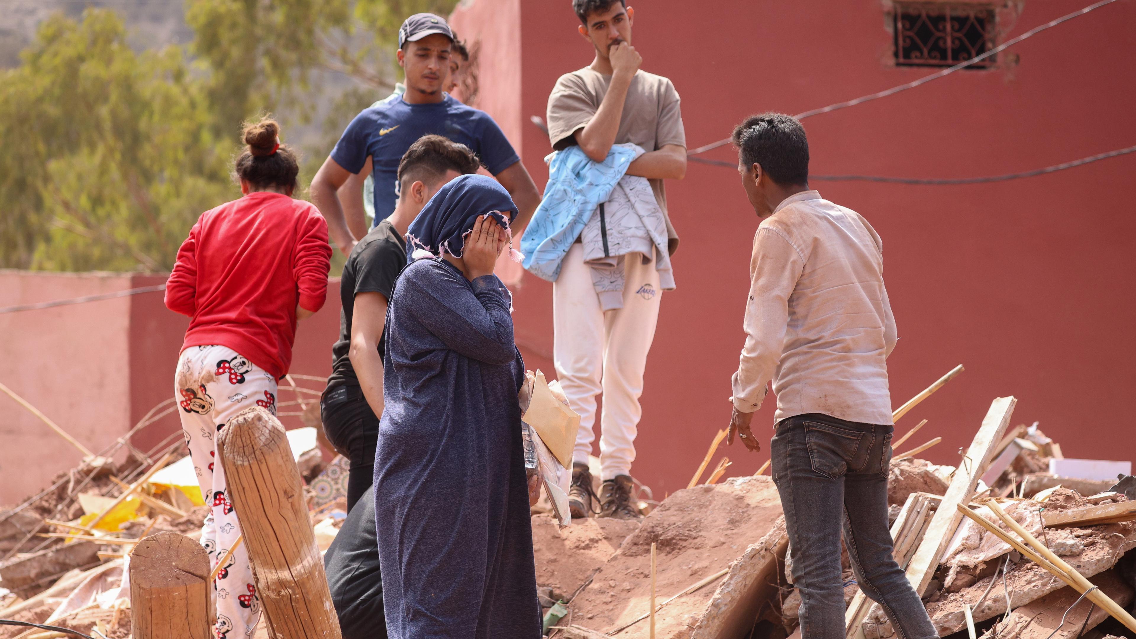 Die Angehörigen eines Erdbebenopfers reagieren, als sie auf Trümmern in Ouirgane, Marokko, stehen.