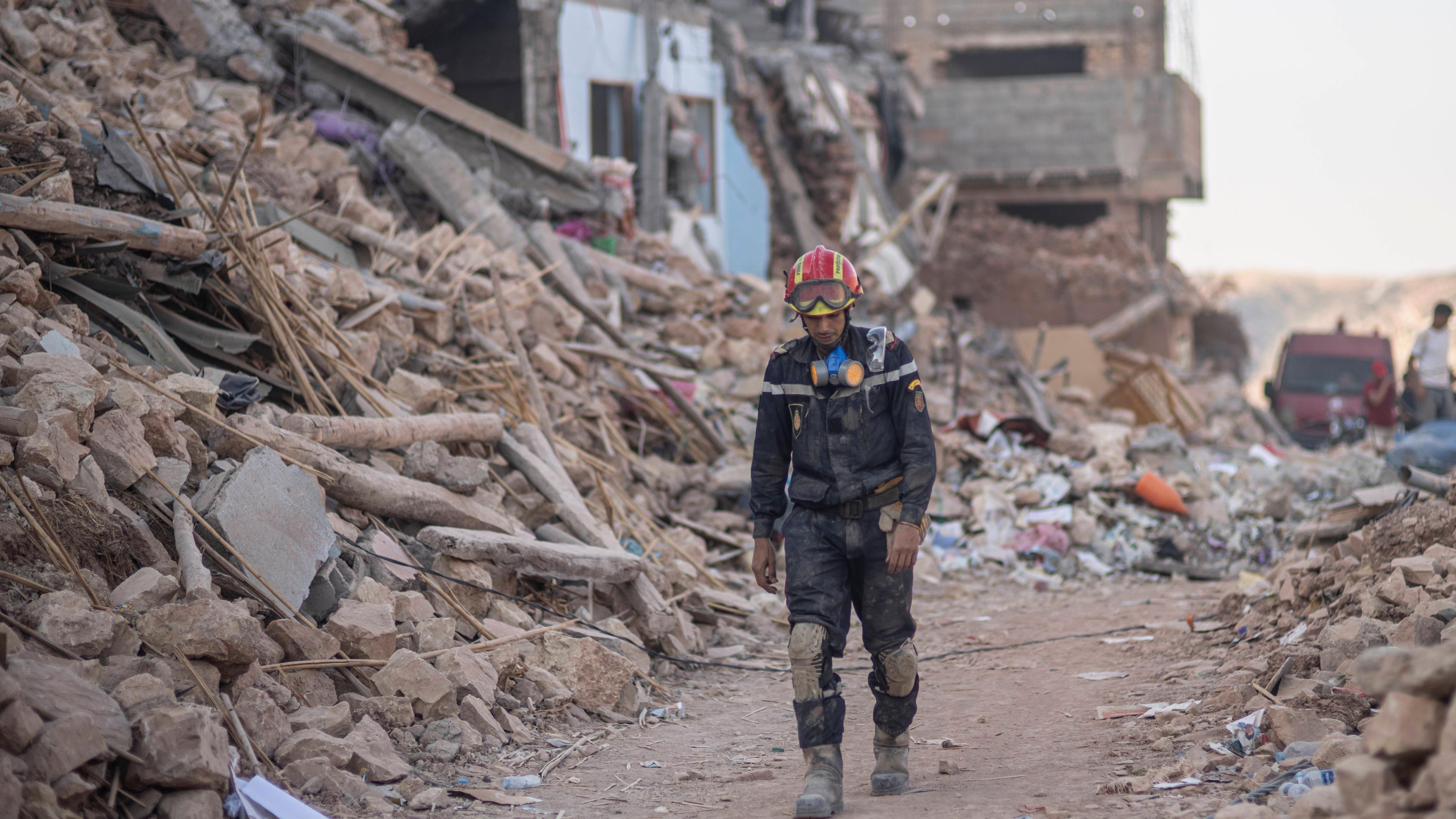 Ein Retter geht durch Trümmer, die durch das Erdbeben in der Stadt Imi N'tala außerhalb von Marrakesch verursacht wurden.