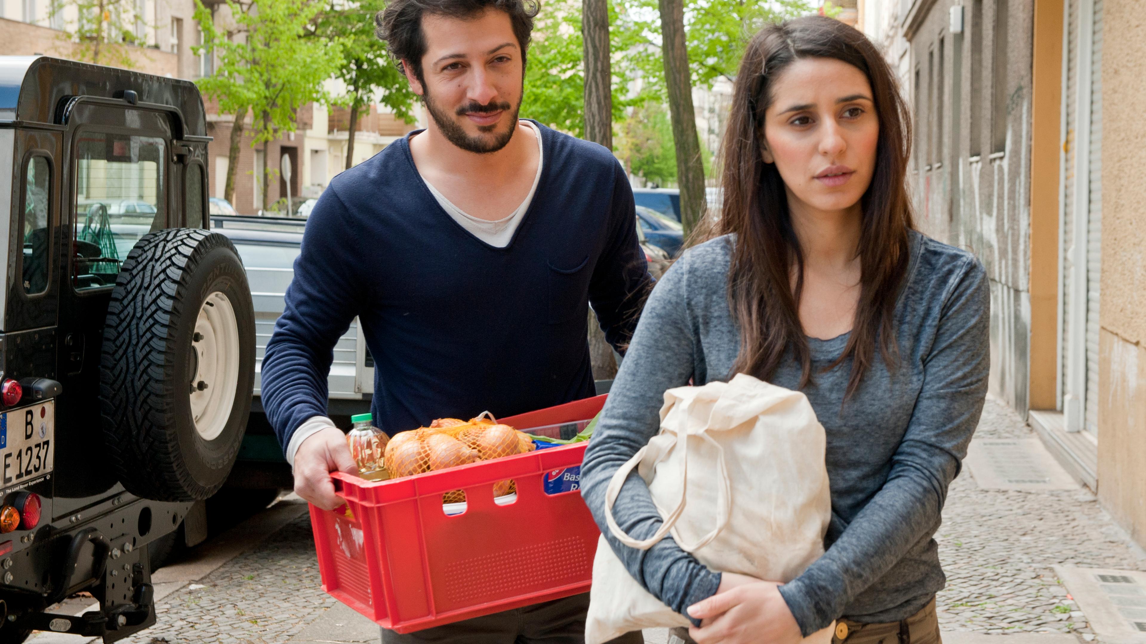 "Marry Me - Aber bitte auf Indisch": Vor Café Devi: Karim (Fahri Yardim) und Kissy (Maryam Zaree) kommen zurück vom Einkauf.