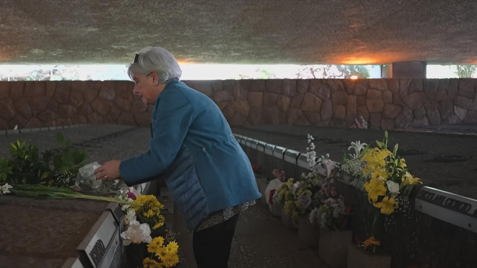 Trauende Frau legt Blumen ab zum Gedenken an das SS Massaker in Rom vor 80 Jahren