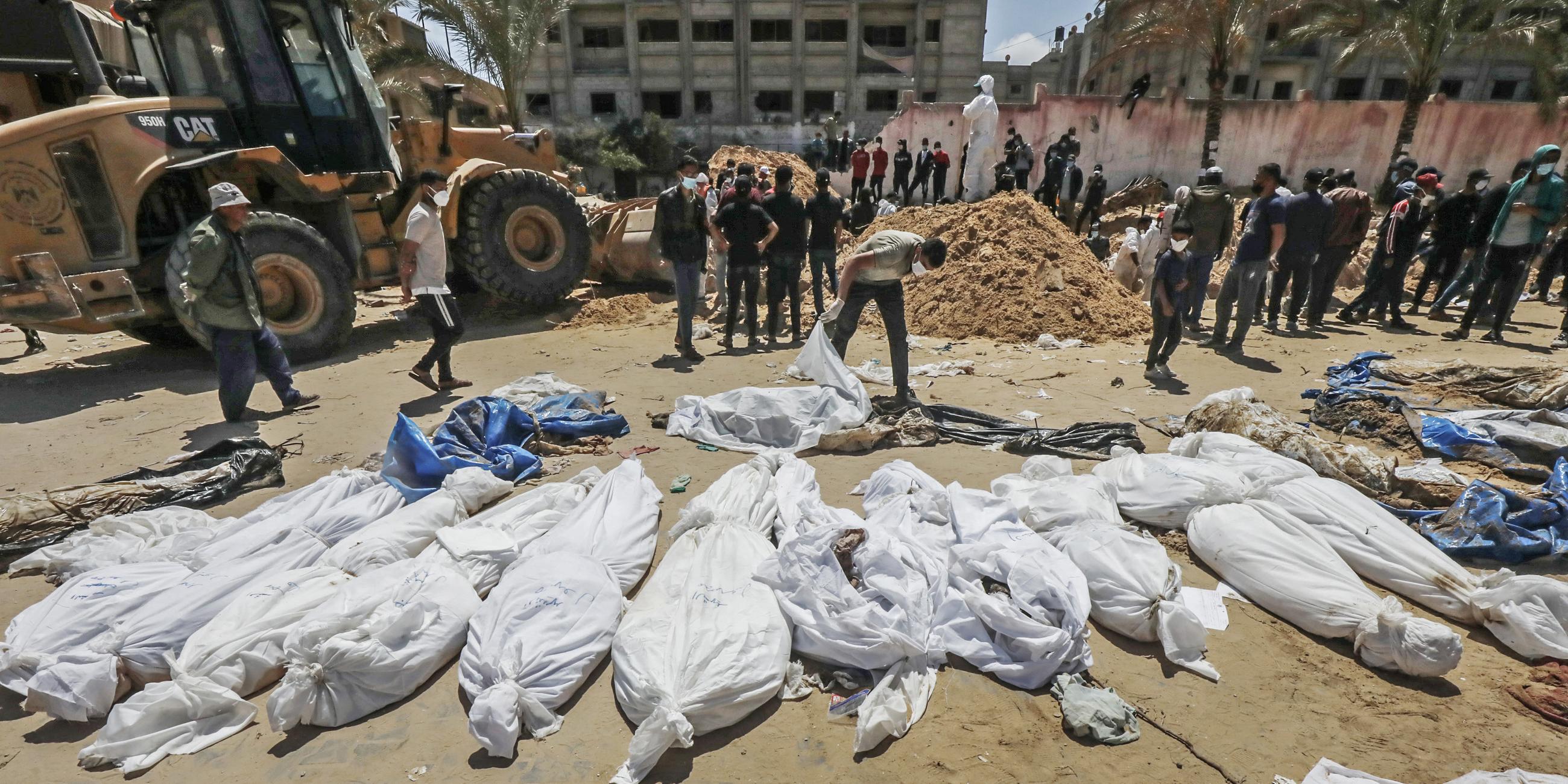 Palästinensische Gesundheitsfachkräfte bergen die Leichen von Palästinensern, die auf dem Gelände des Nasser-Krankenhauses begraben wurden, aufgenommen am 21.04.2024
