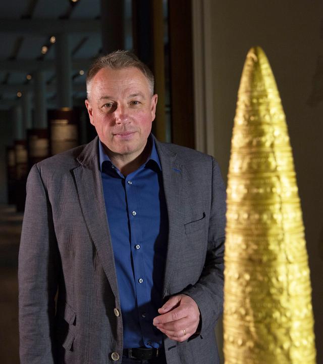 Matthias Wemhoff mit Goldhut im Neuen Museum Berlin